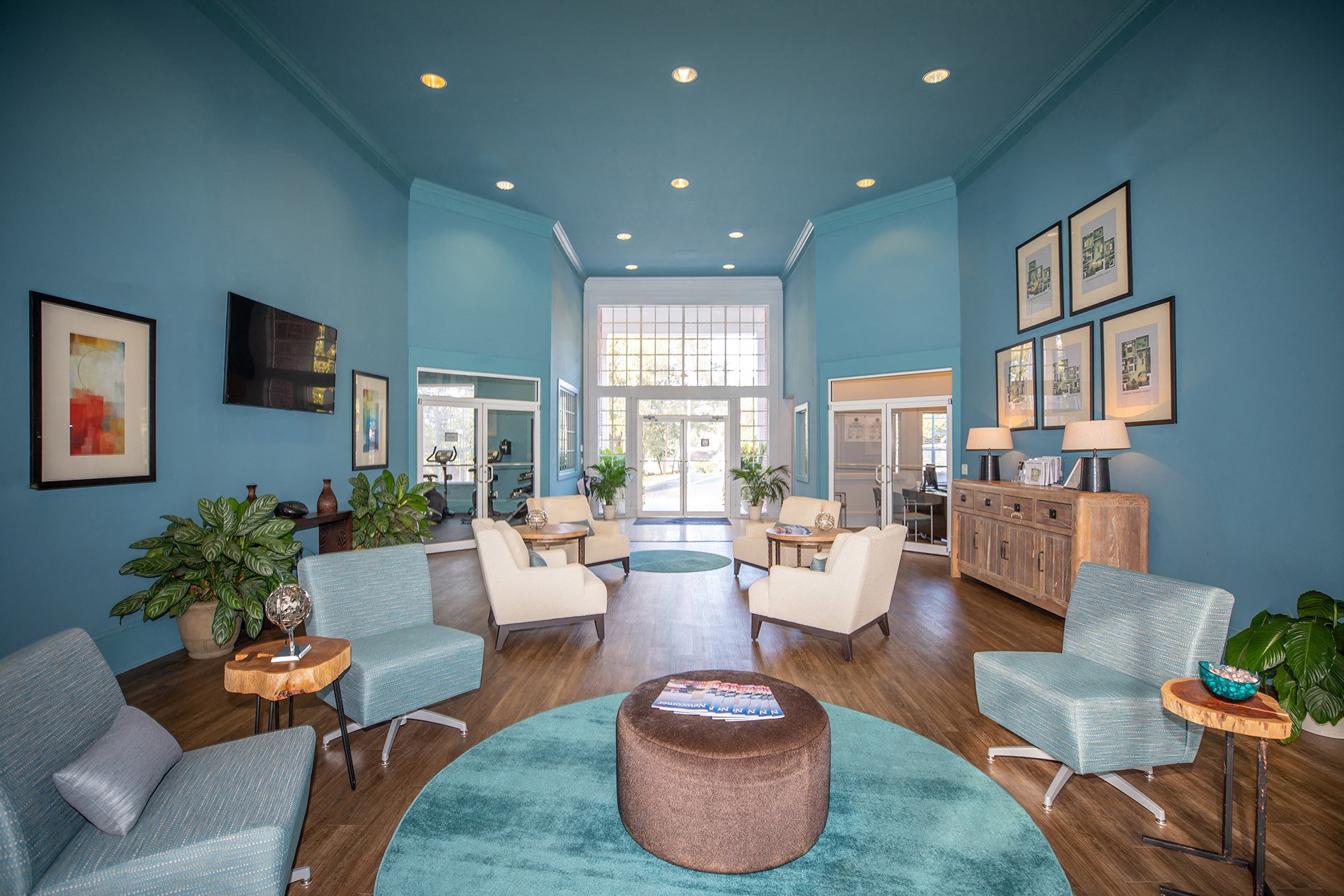 a living room with blue walls and furniture and a large window